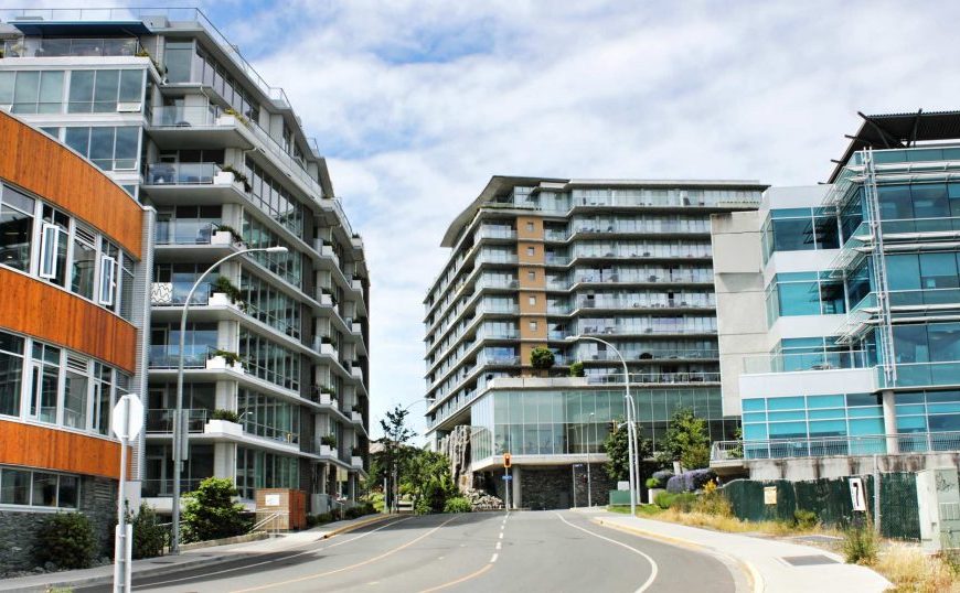 A street with a row of buildings in the background.
