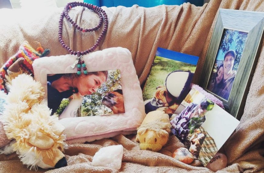 A couch with stuffed animals and pictures on it.