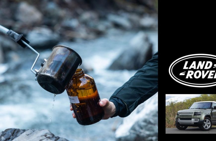 A person is holding a mug with the words land rover on it.