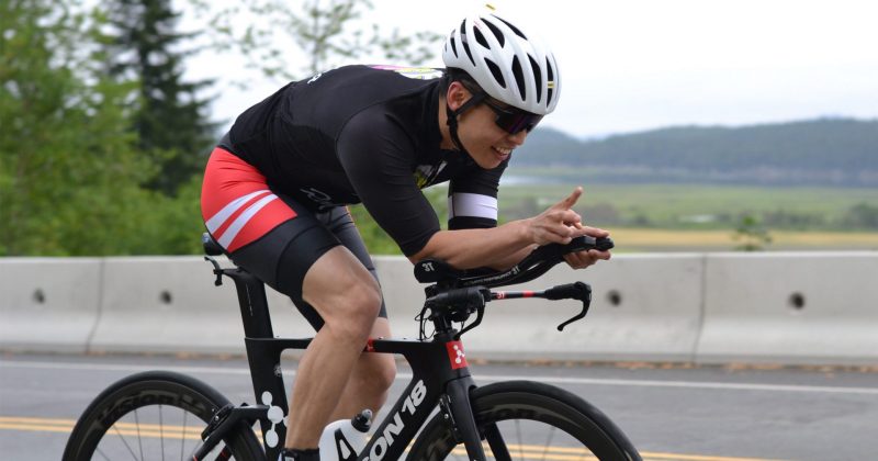 A man is riding a bike on a road.