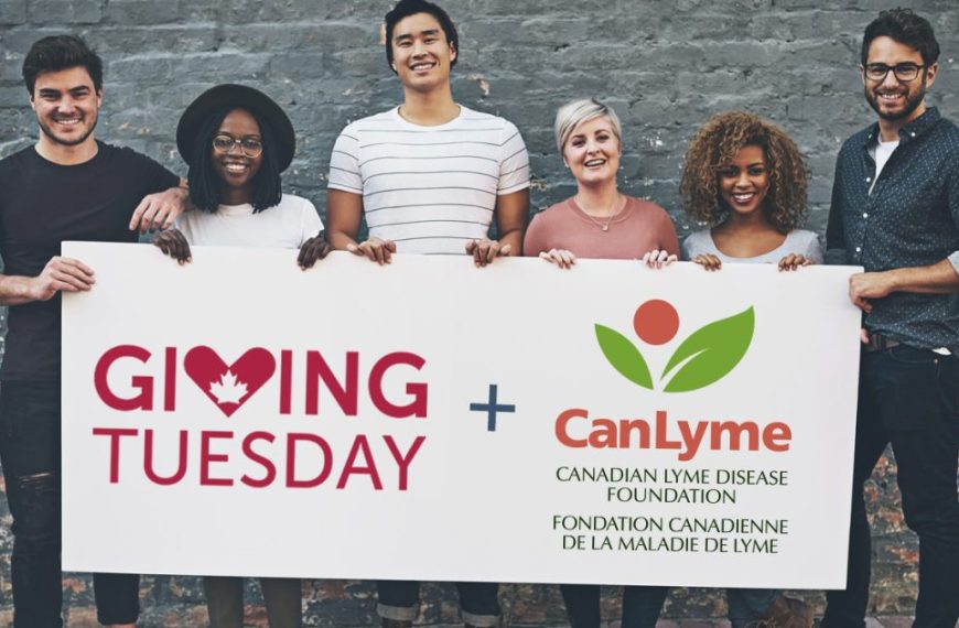 A group of people holding up a sign that says giving tuesday.