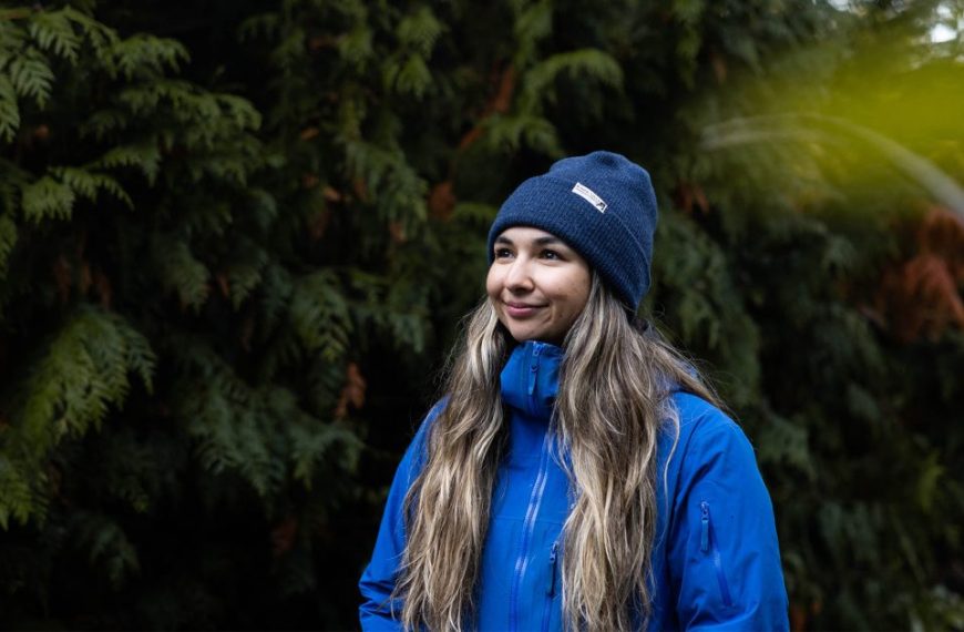 A woman wearing a blue jacket and beanie.