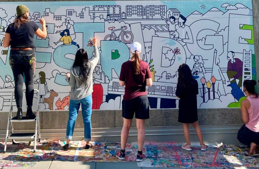 A group of people painting a mural on a wall.