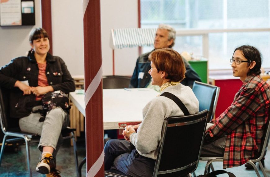 A group of people sitting around a table in a room.