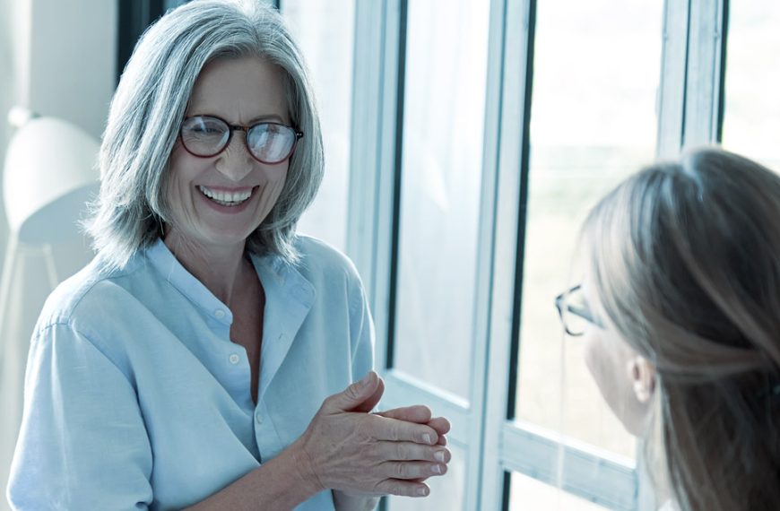 An older woman is talking to a younger woman in an office.