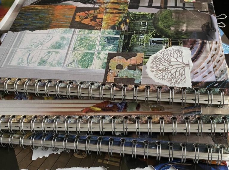 A stack of spiral notebooks on top of a table.