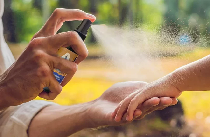 A man spraying a child's hand with a spray bottle.