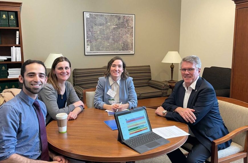 Four people sitting around a table in an office.