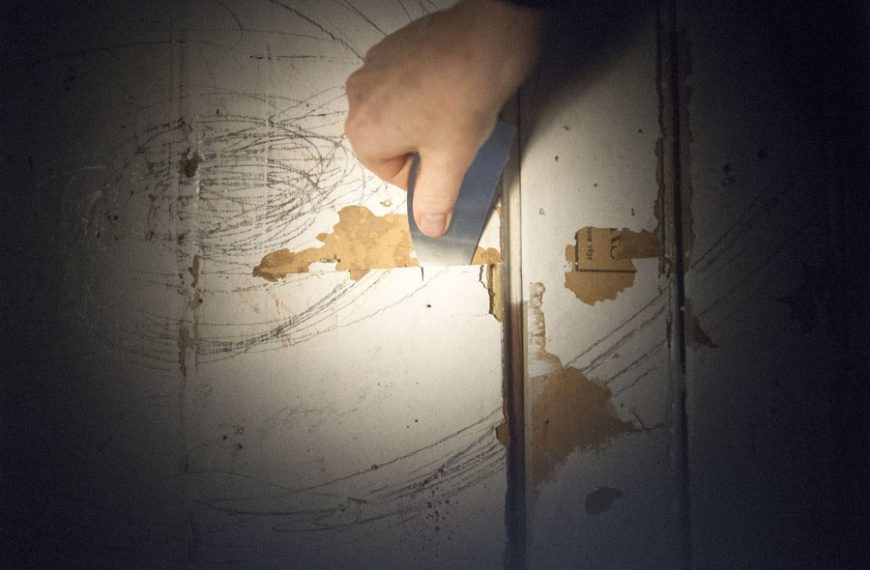 A person using a knife to cut a piece of paper.