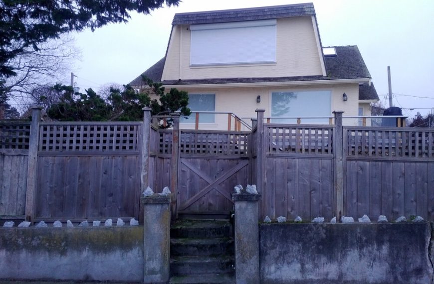 A house with a fence and a wooden gate.