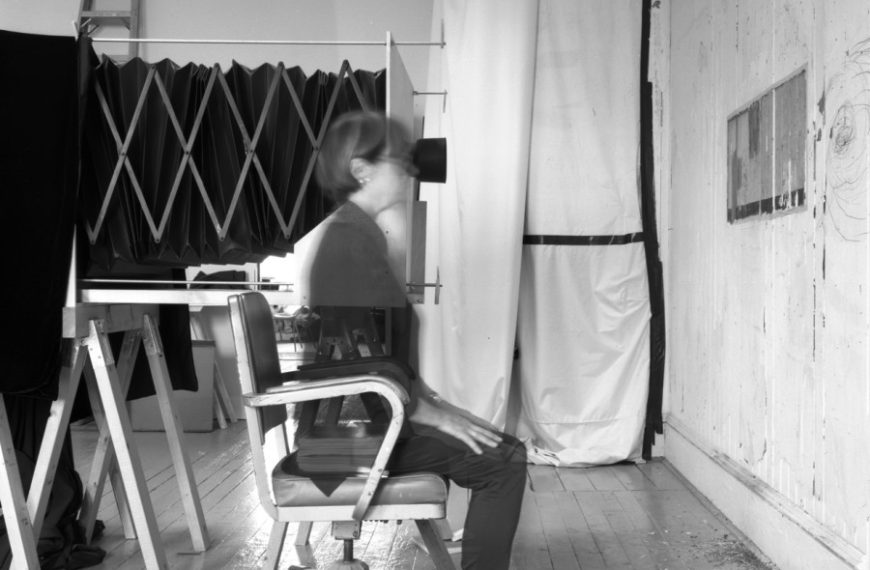 A black and white photo of a man sitting in a chair.