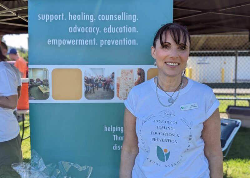 A woman standing in front of a tent with t - shirts.