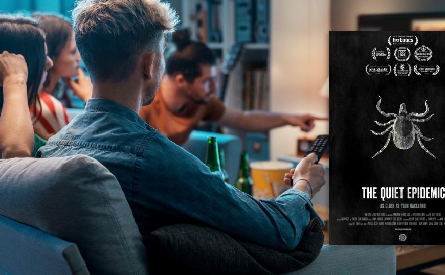 A group of people sitting on a couch watching a movie.