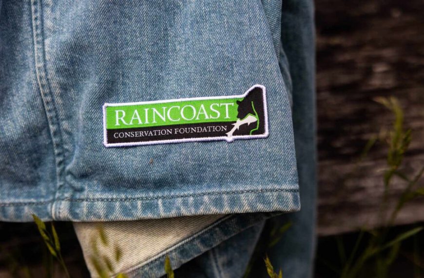 A denim jacket with a green sticker on it.