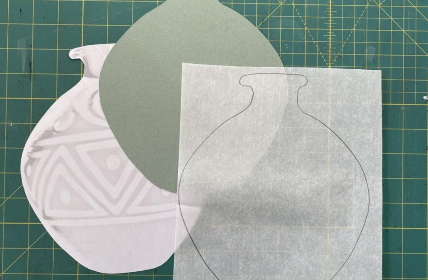 A pair of paper vases on a cutting mat.