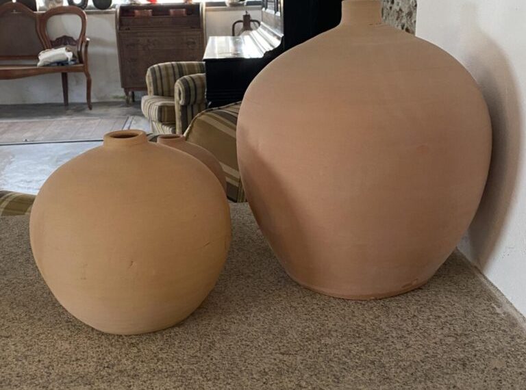 Two terracotta vases sitting on a counter.