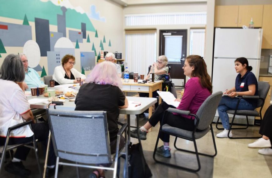 A group of people sitting around a table in a room.