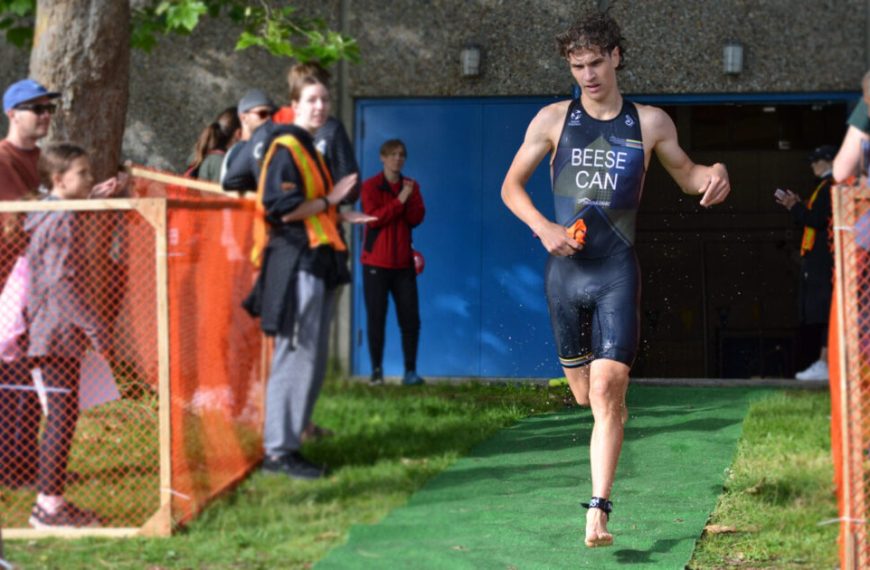 A man running on a green carpet in front of spectators.