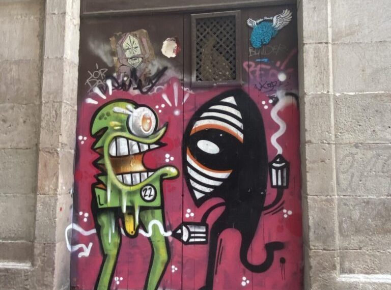 A graffitied door with a cartoon character on it.