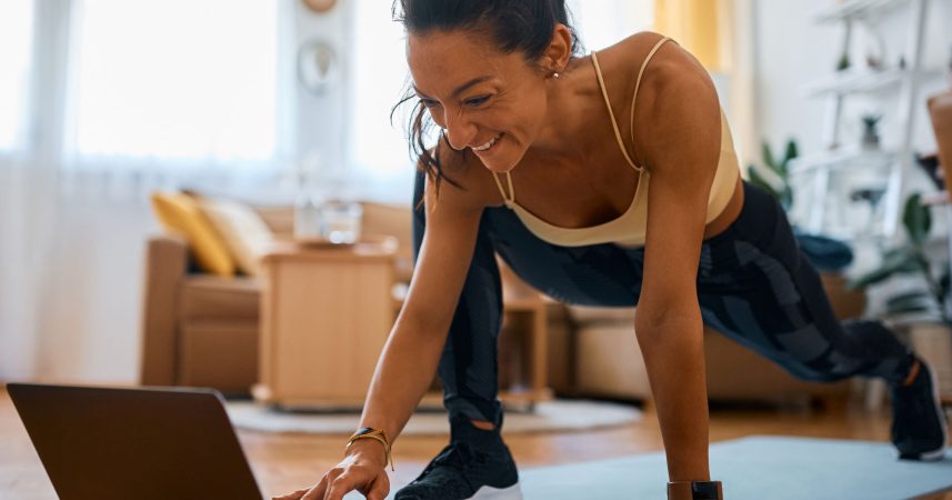 A woman doing push ups on a laptop.