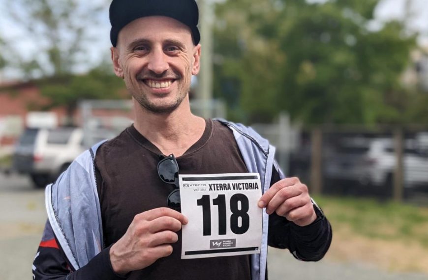 A man holding up a number sign in a parking lot.