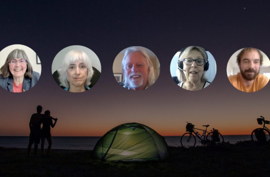 A group of people standing around a tent at night.