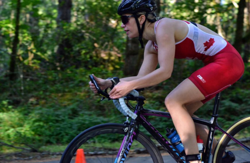A woman is riding a bike in the woods.