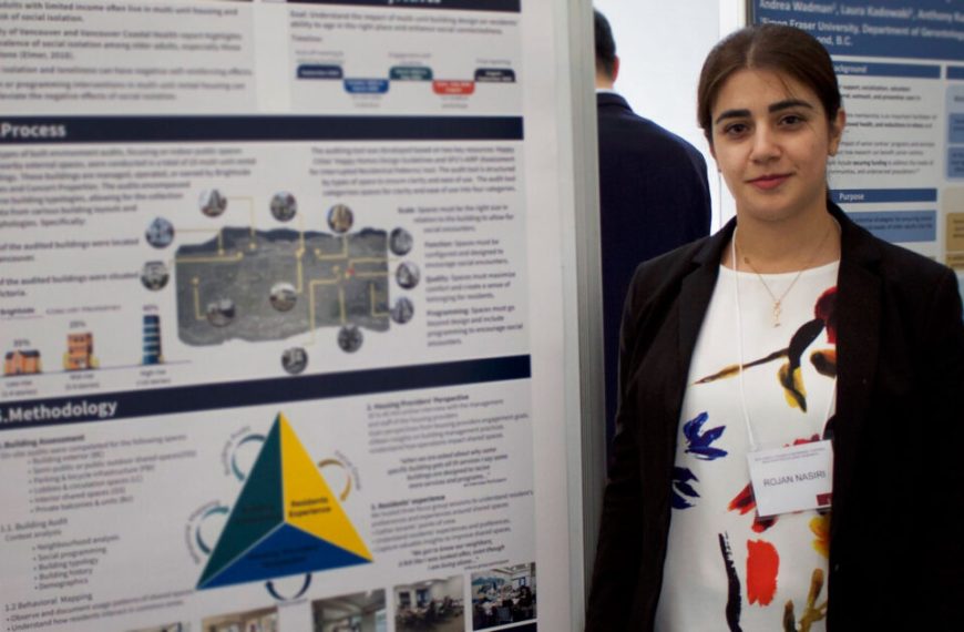 A woman standing in front of a poster.