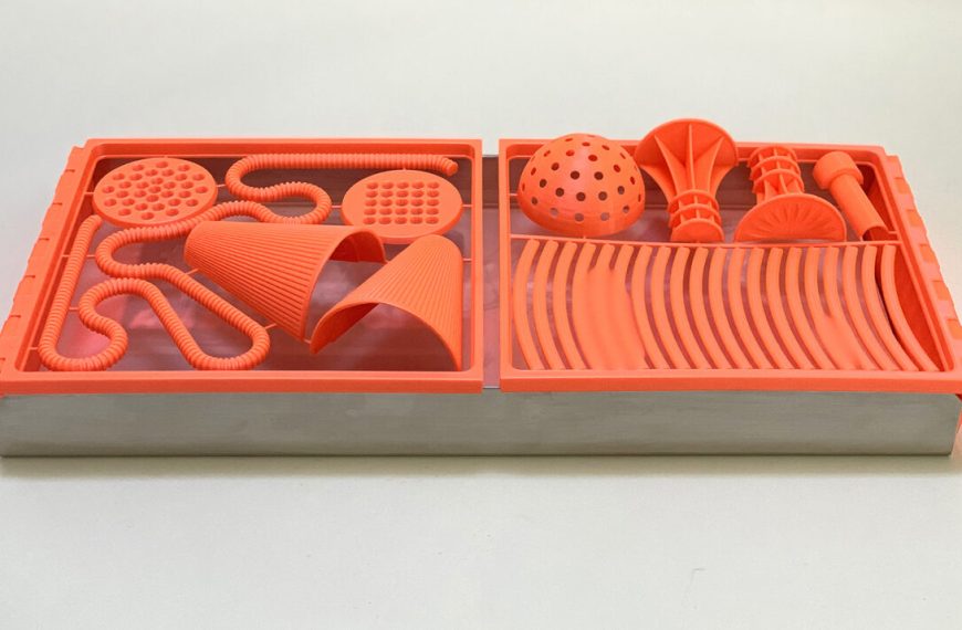 A set of orange plastic utensils in a box.