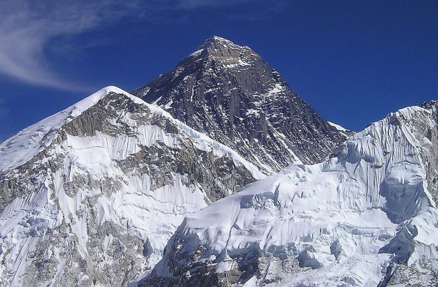 A mountain covered in snow with a blue sky.