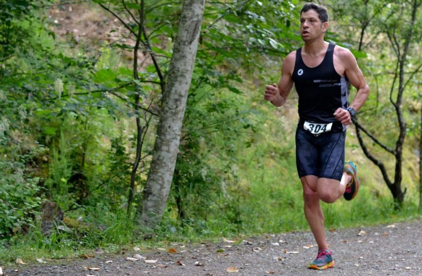 A man running down a path in the woods.