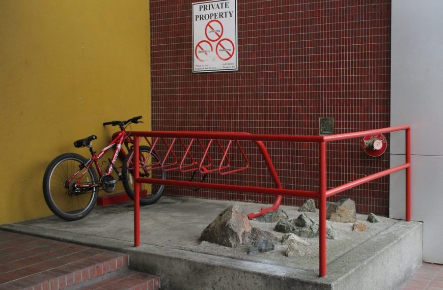 A bike is parked on a rack in front of a building.