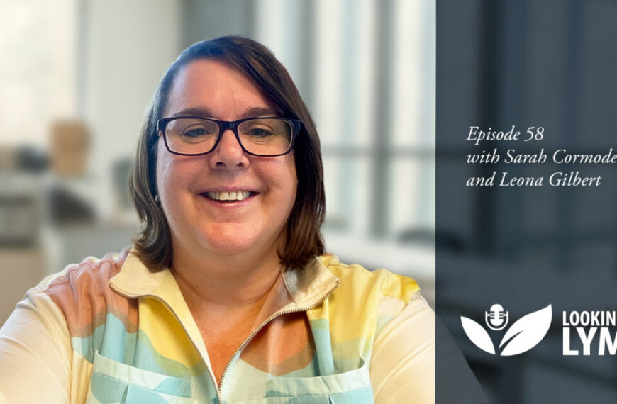Dr. Leona Gilbert, a woman in glasses, is smiling while holding a bonus episode of 'Lyme' under the microscope.