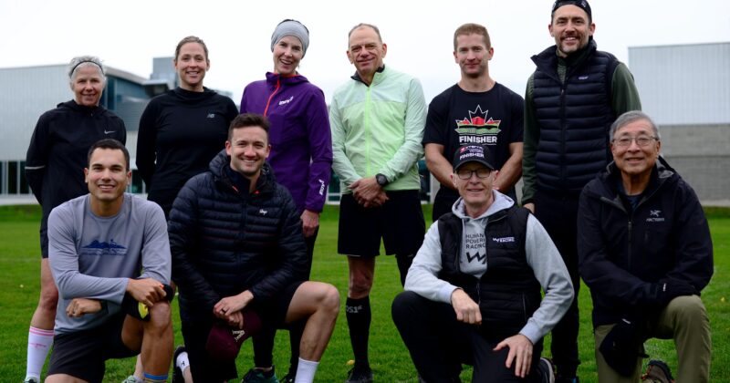 A group of people participating in Triathlon BC coaching clinics on a field.