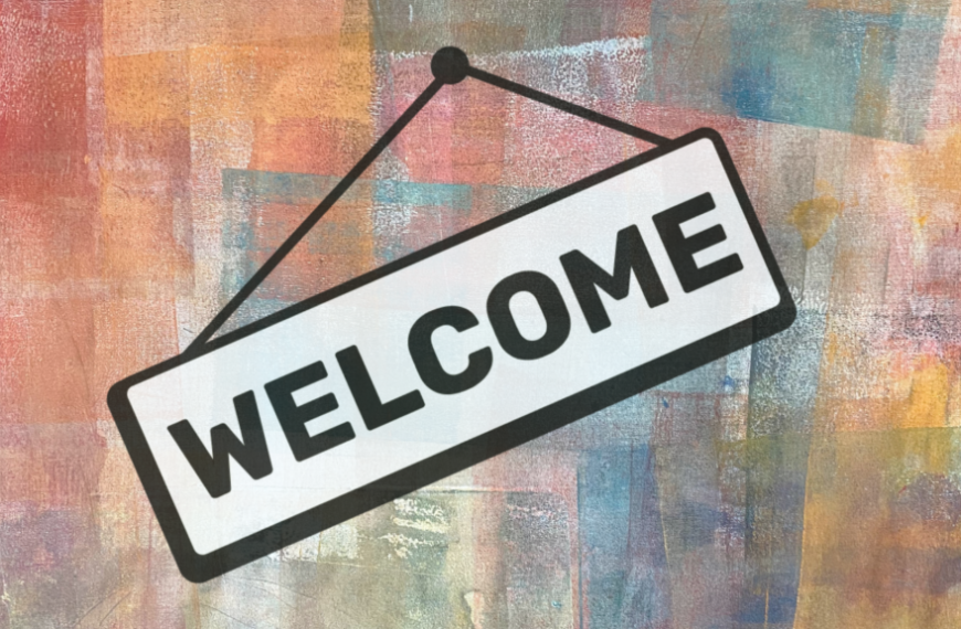 A Welcome sign created on a colorful background for the registration counter at the Create2Flourish event.