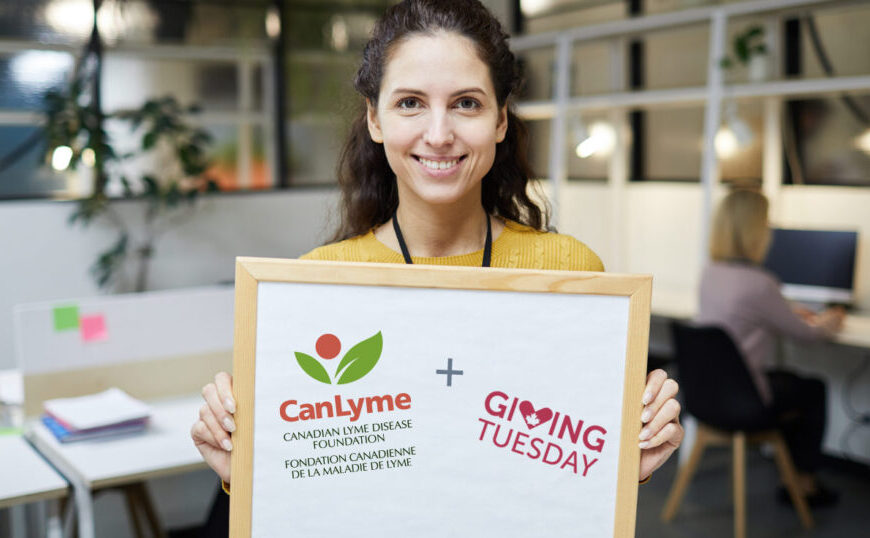 A woman is holding up a sign that says "calyme" on Giving Tuesday, aiming to spark hope and create change.
