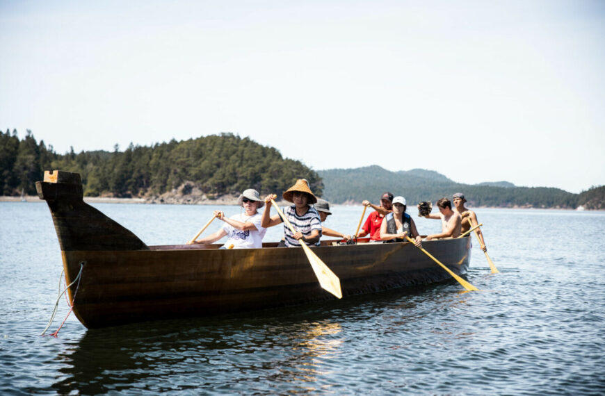 A Reconcili-Action group paddling in a canoe on the TŦE ṮEṮÁĆES.