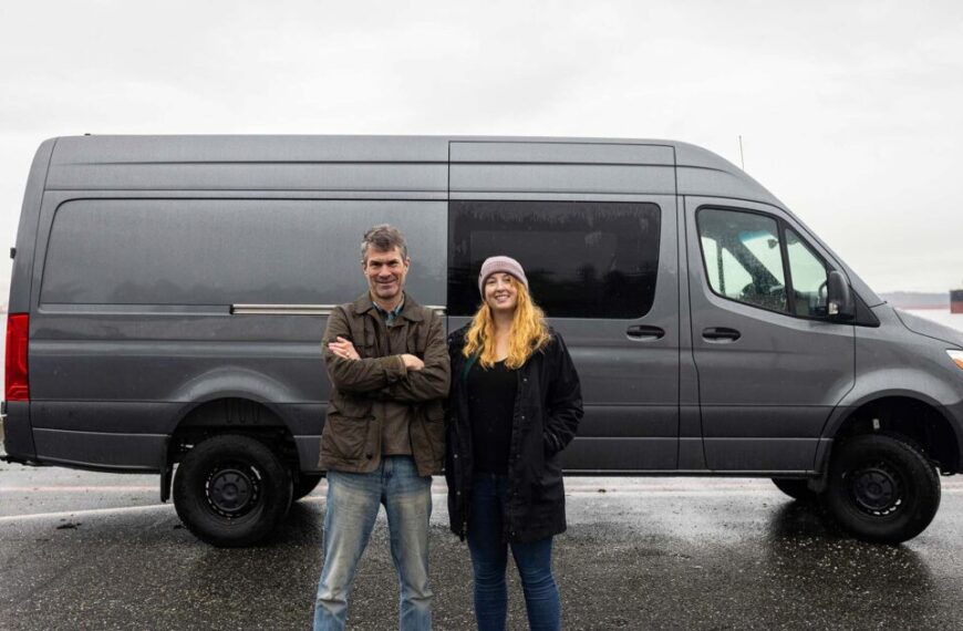Two people standing in front of a mobile lab van.