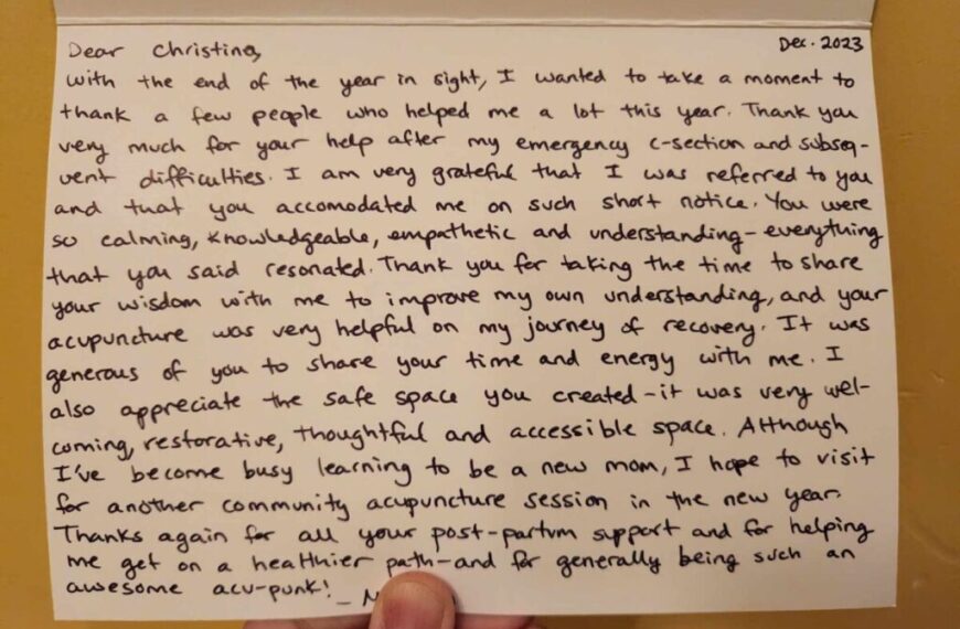 A person holding up a letter filled with heartfelt holiday gratitudes handwritten on it.