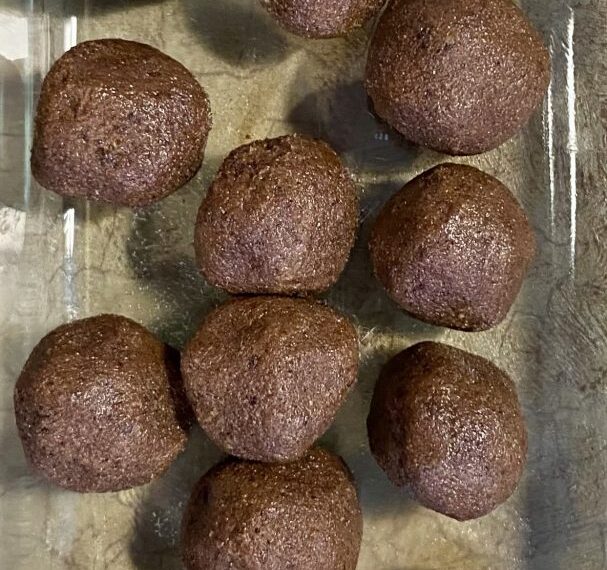 Milk chocolate truffles on a glass plate.