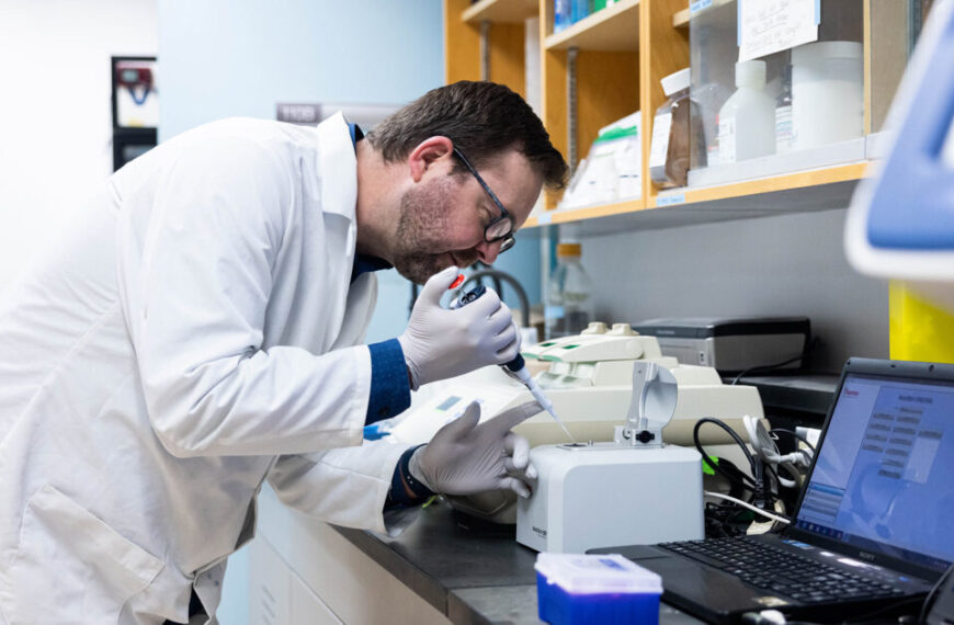A man in a lab coat conducting DNA research in a genetics lab.