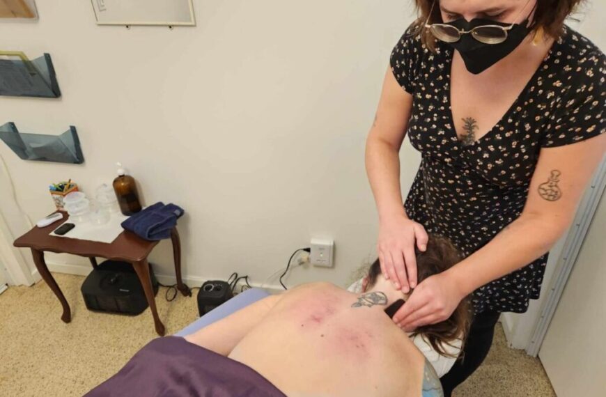 A woman is getting a tattoo on her back, creating a stunning design on her skin barrier.