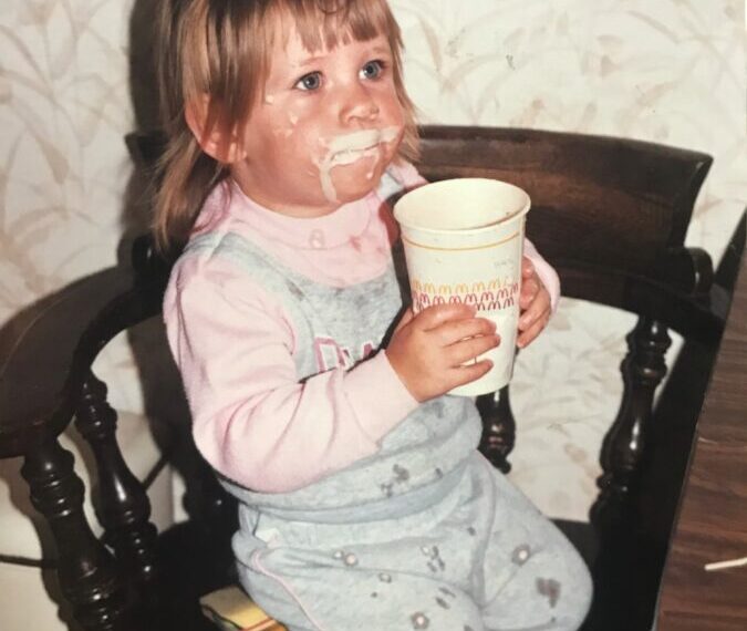 Sarah, a little girl, sitting in a chair with a cup of coffee.