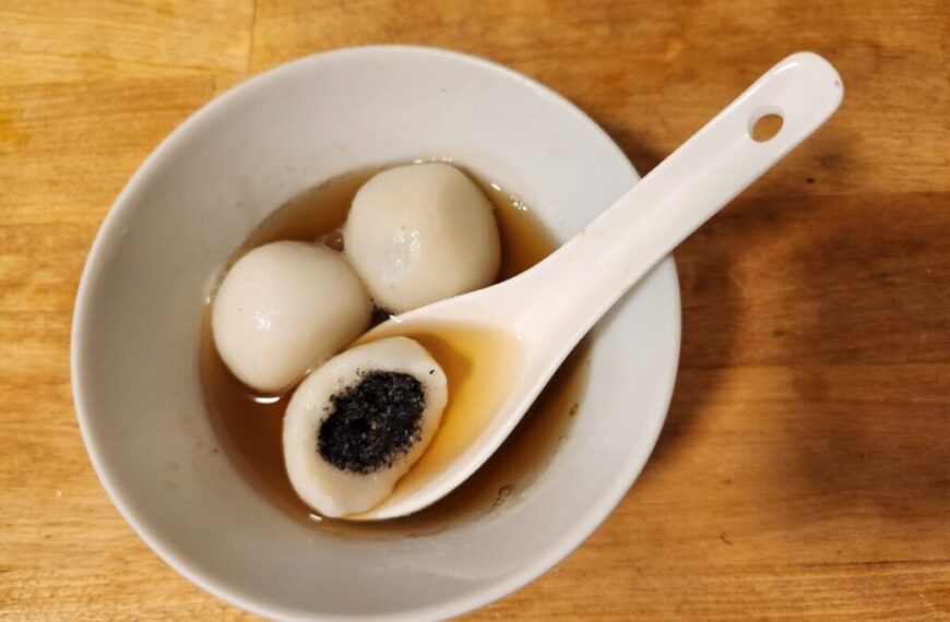 A white bowl filled with Tang Yuan, a traditional Lunar New Year dish made of two glutinous rice balls, symbolically representing the support of kidneys.