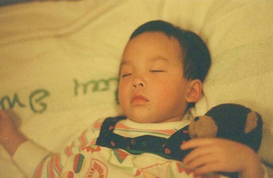 A baby laying on a bed with a teddy bear. Additionally, learn more about Christina.