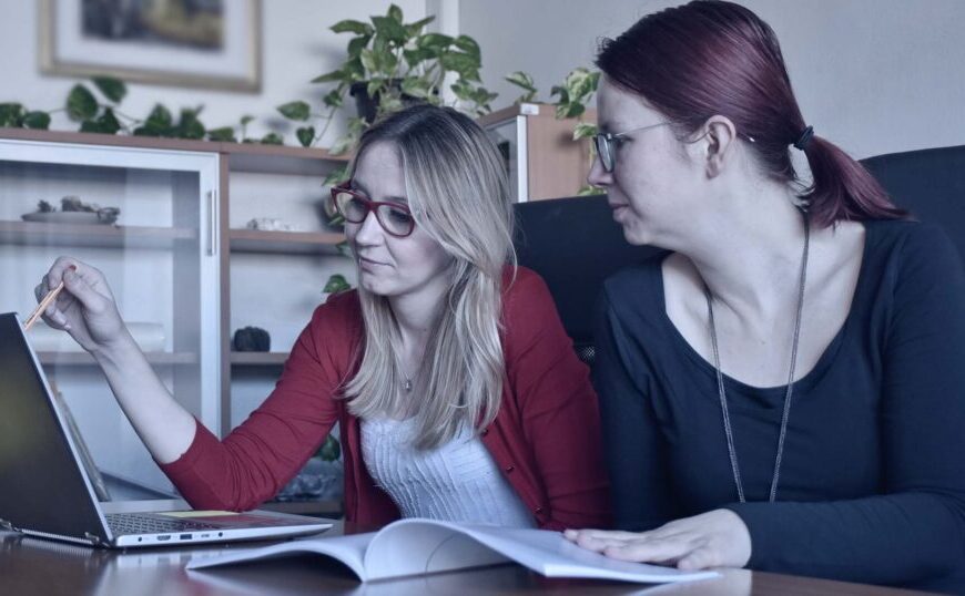 Two women sitting at a desk researching Lyme disease and pregnancy.