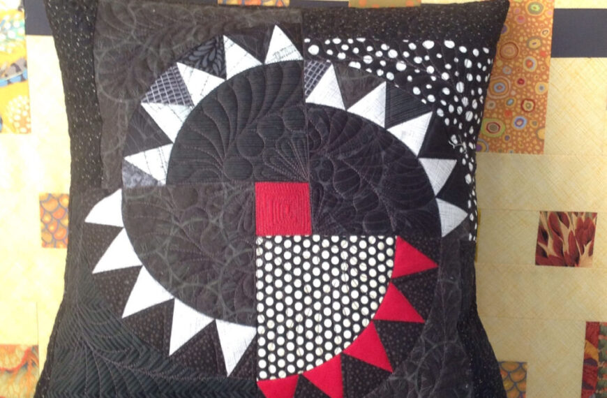 A black and white pillow with a dreaming red and white design.