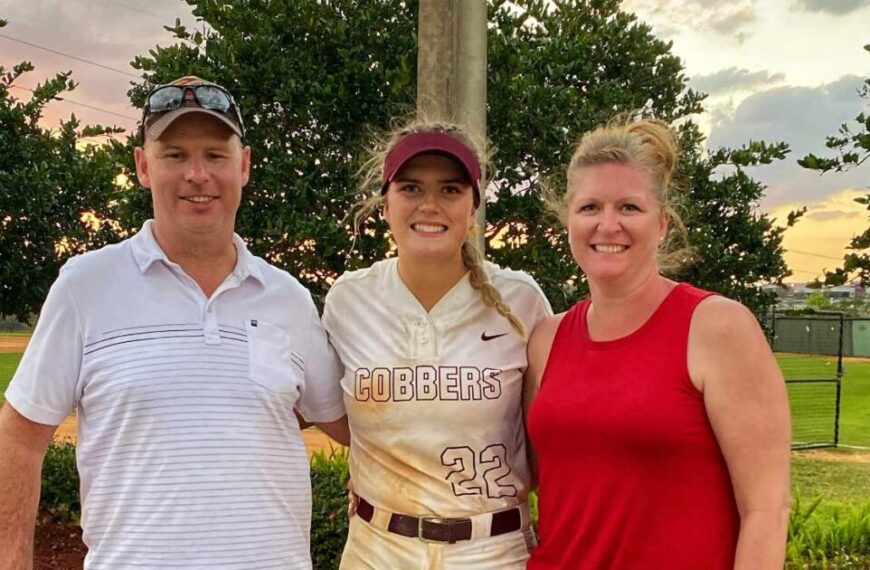 Three people pose for a photo outside. A young woman in a "Cobbers" sports uniform stands between a man in a white shirt and a woman in a red tank top, perhaps celebrating their shared journey through university and the emotional intelligence they've gained along the way.