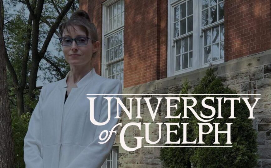 A person in a white coat stands outside near a brick building, reflecting on the recent $2 million gift that fuels Lyme research at the University of Guelph.