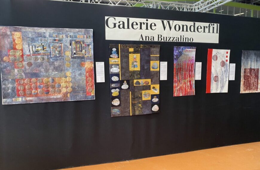 A gallery wall in Nantes displays six colorful abstract textile artworks from the "Threads across Continents" series, with a sign reading "Galerie Wonderfil Ana Buzzalino" above them. Descriptions are mounted next to each piece.